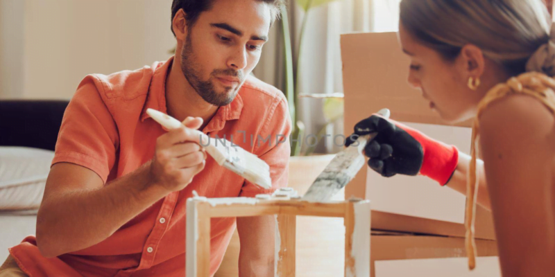 Couple painting wooden furniture white